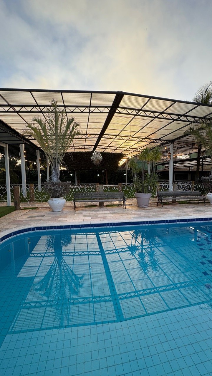 Piscina e área coberta do Espaço Dois Irmãos, refletidas na água.